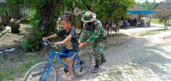 Satgas TMMD 110 Bojonegoro Bantu Anak-Anak Dusun Kramanan Belajar Sepeda